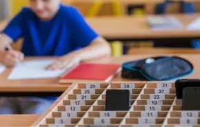 School kids placing putting phones away during class