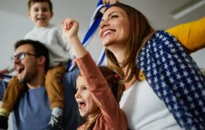 family cheering while watching game at home