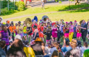 crowd watching a marching bad with big instruments play during Honk Fest West in Seattle
