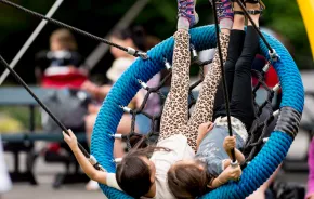kids swinging on the Artists at Play Playground in Seattle Center, a fun weekend activity for Seattle families