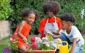mom and kids planting flowers