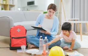 mom and daughter packing an emergency backpack with supplies