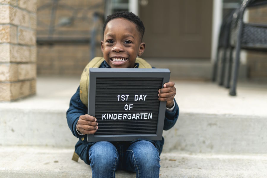 Boy holding sign for his first day of kindergarten