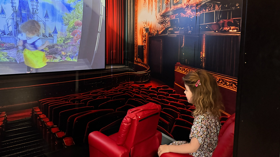 girl watching a movie in the theater at Nick's Magnificent indoor playground in Issaquah