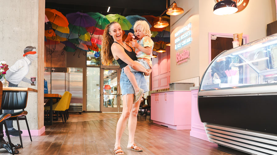 interior of Besito ice cream with an umbrella-decorated ceiling and smiling mom with kid