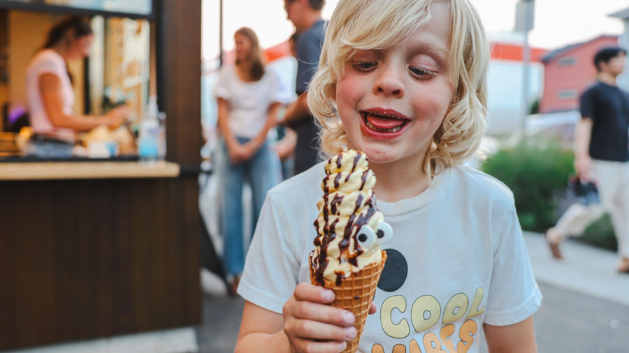kid looking at unique ice cream cone swirled with toppings at Many Bennies in Fremont