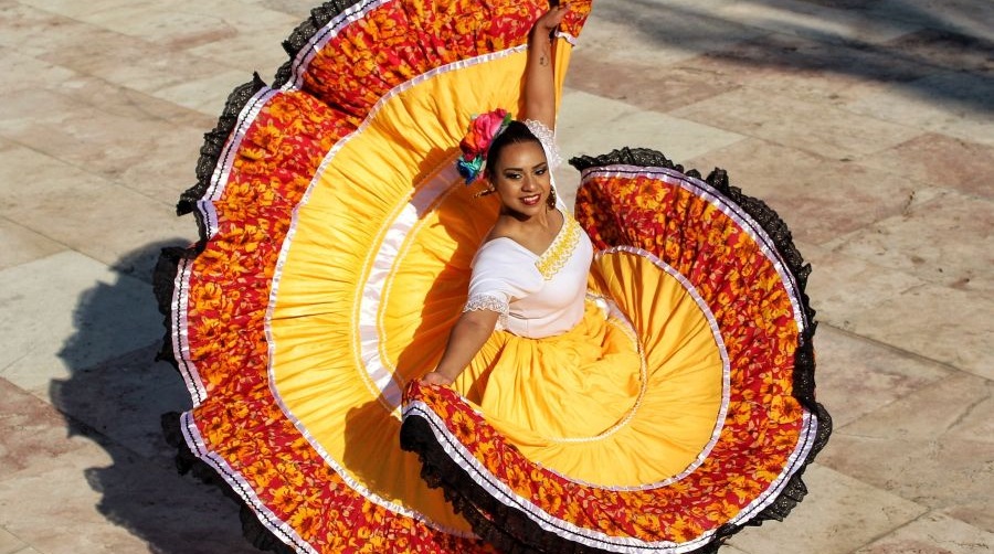 A dancer wearing a colorful dress performs for Hispanic Heritage Month.