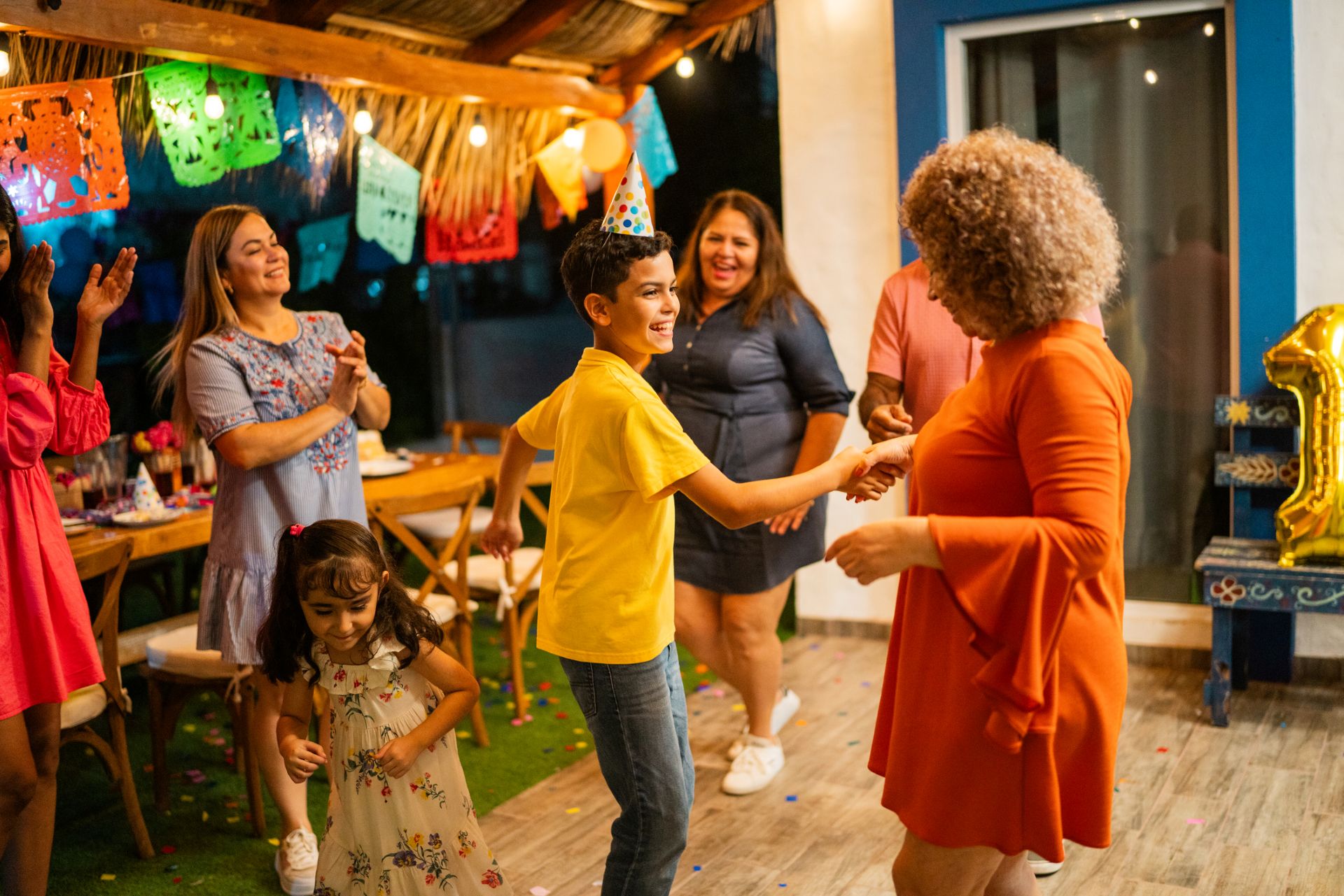 A boy dances with his family at a fiesta.