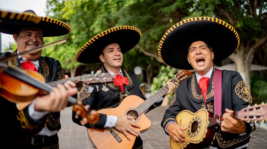 A trio of mariachi musicians play traditional celebratory music. 