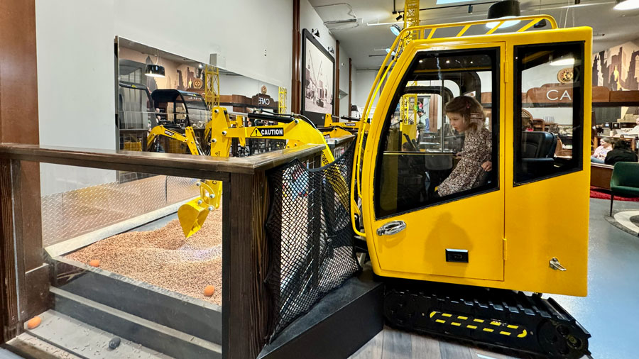 kid operating an excavator inside Nick's Magnificent, an indoor playground and perfect thing to do with toddlers near Seattle