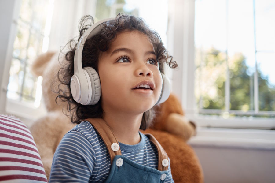 young girl listening to podcast with headphones
