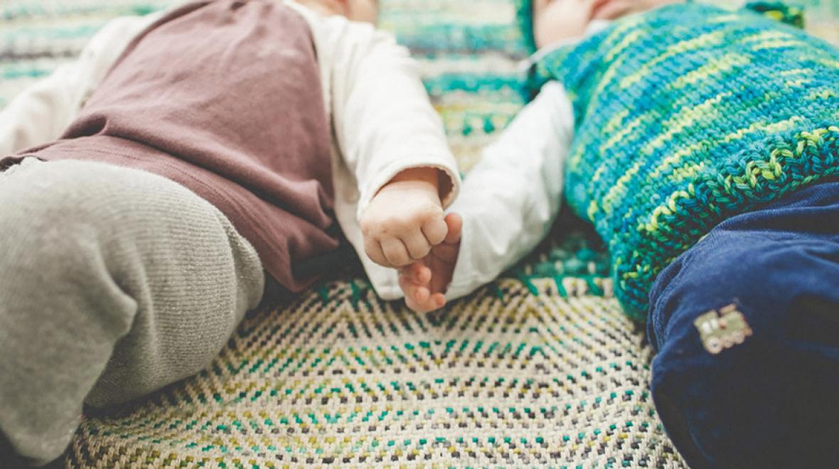 Two babies holding hands
