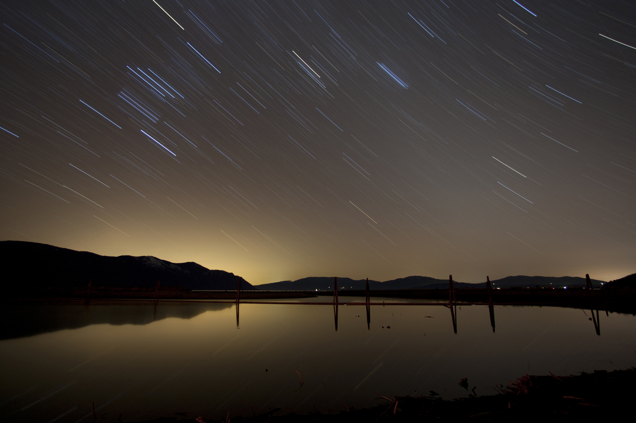 Star trails over Lake Pend Oreille in Sandpoint, Idaho, a pacific northwest road trip destination for summer mountain fun at Schweitzer and lake fun at Lake Pend Oreille
