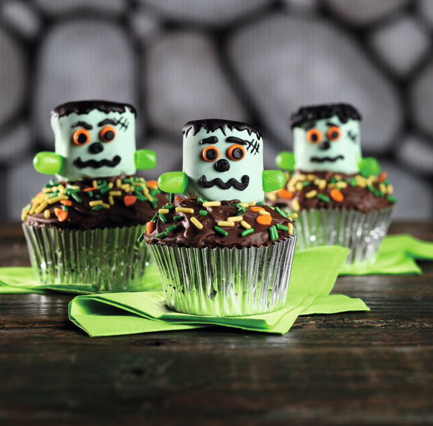 Three cupcakes decorated with friendly looking monsters