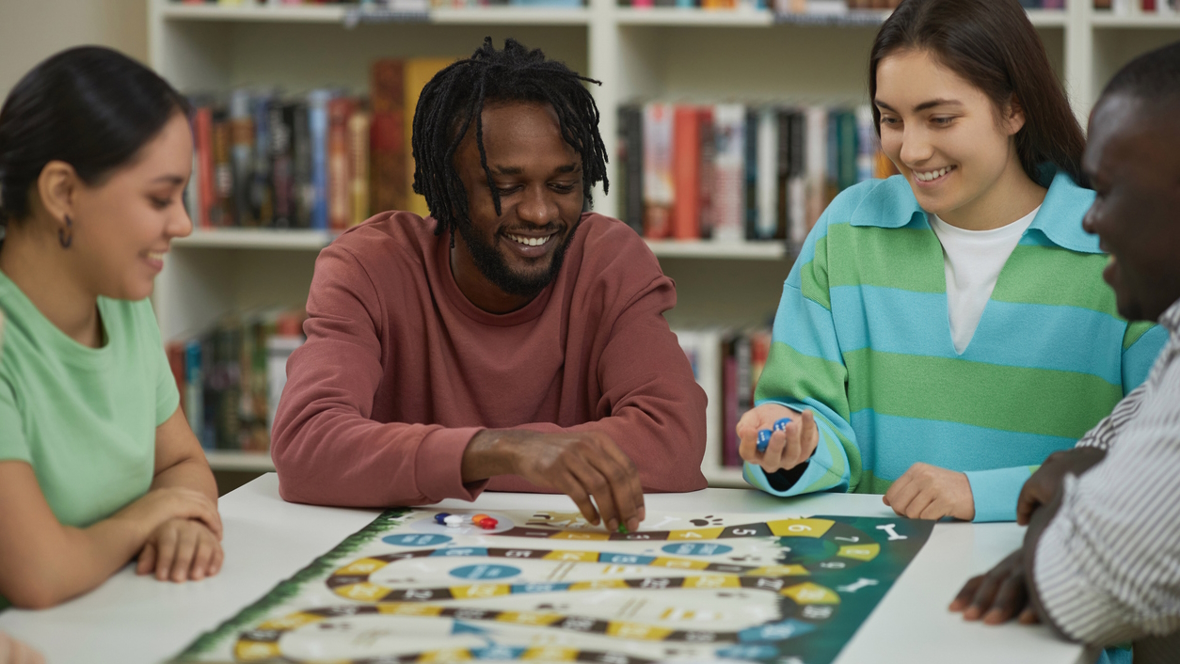 Teens playing board games together and smiling