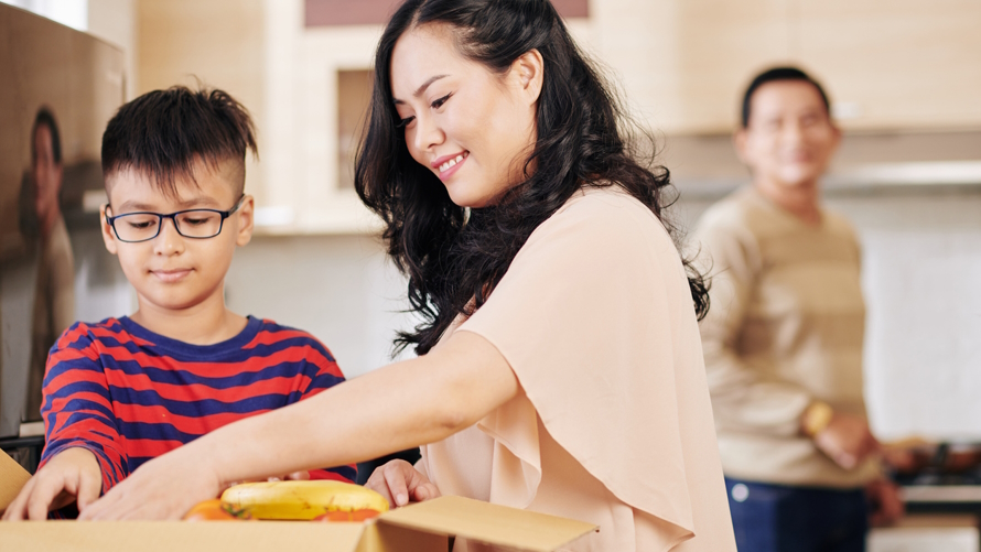 Mom and son opening up a meal prep box part of a Seattle meal kit service