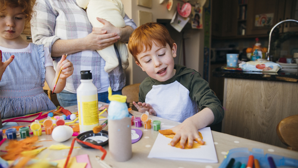 young boy making crafts in his home