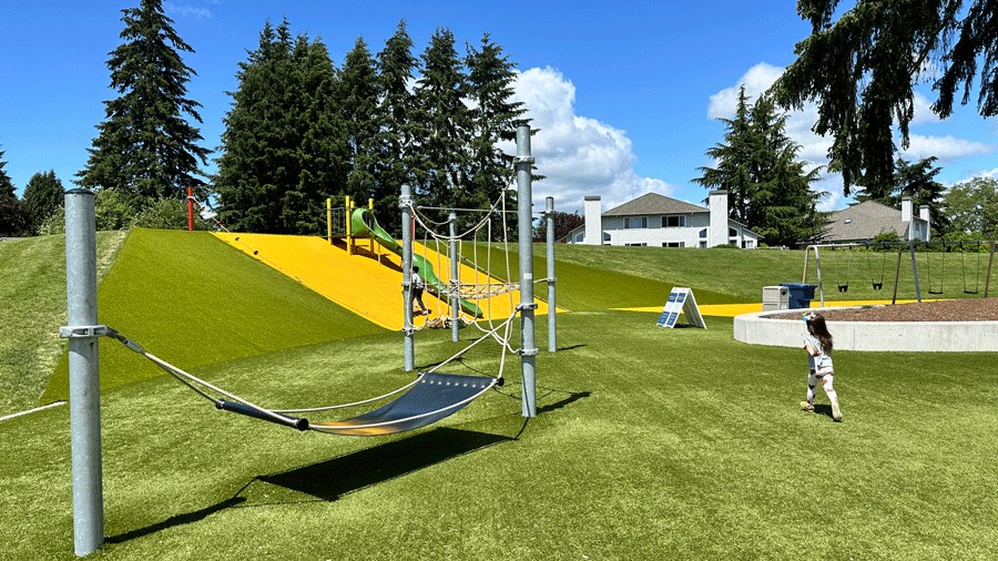 A young child heads toward the fun playground structure at 132nd Square Park on the Eastside