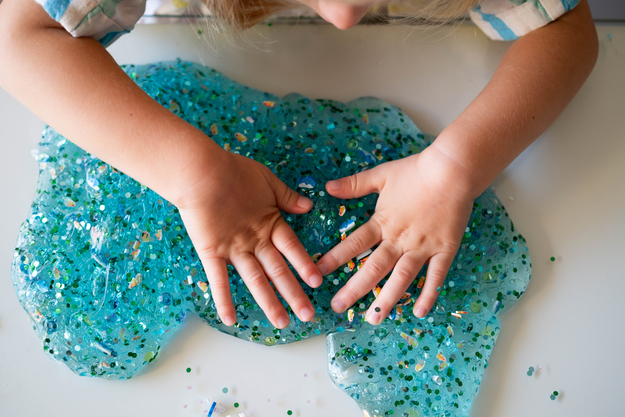 a child plays with DIY glitter slime from a birthday goody bag