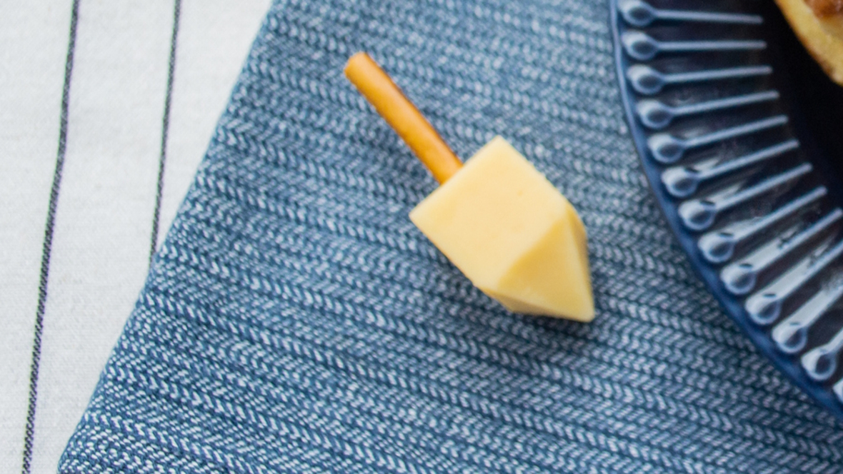 A dreidel made from cheese and a pretzel, fun holiday snack to make with kids