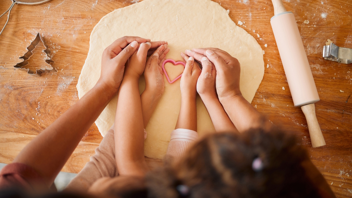 child and parents making valentines treats together