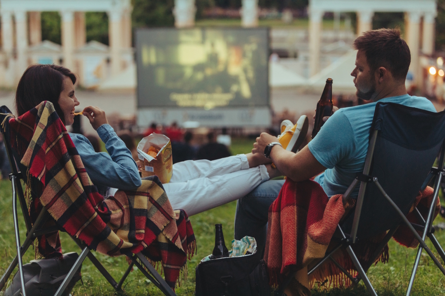couple enjoying an outdoor movie as a date night in the summer