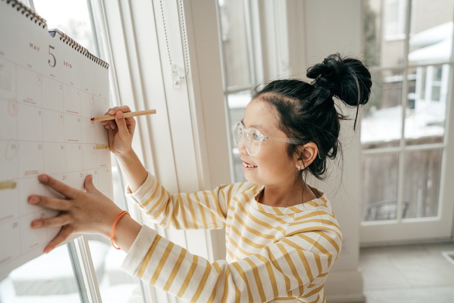 girl writing her start and end date on a calendar for resolutions