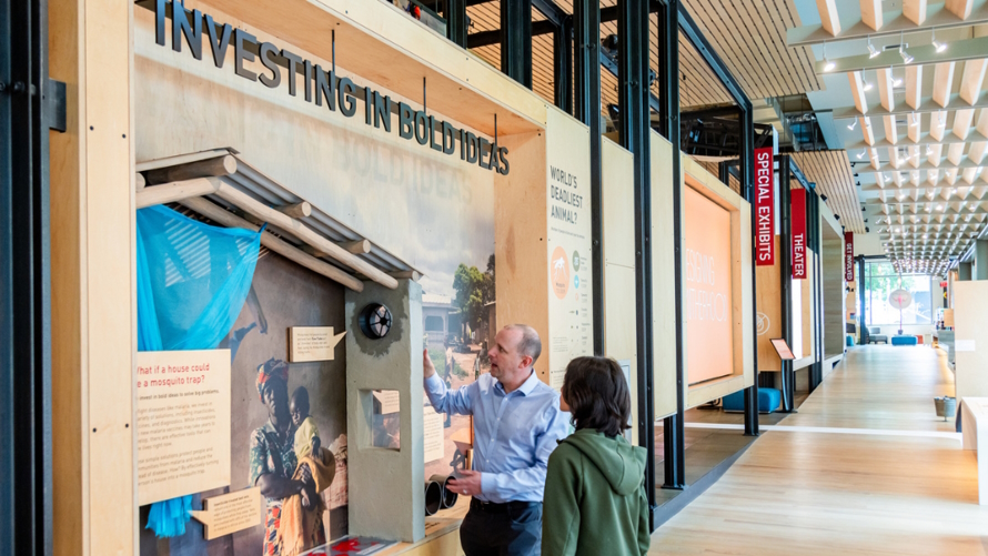 a man and child learning about the new exhibit at the Gates Foundation Discovery Cetner