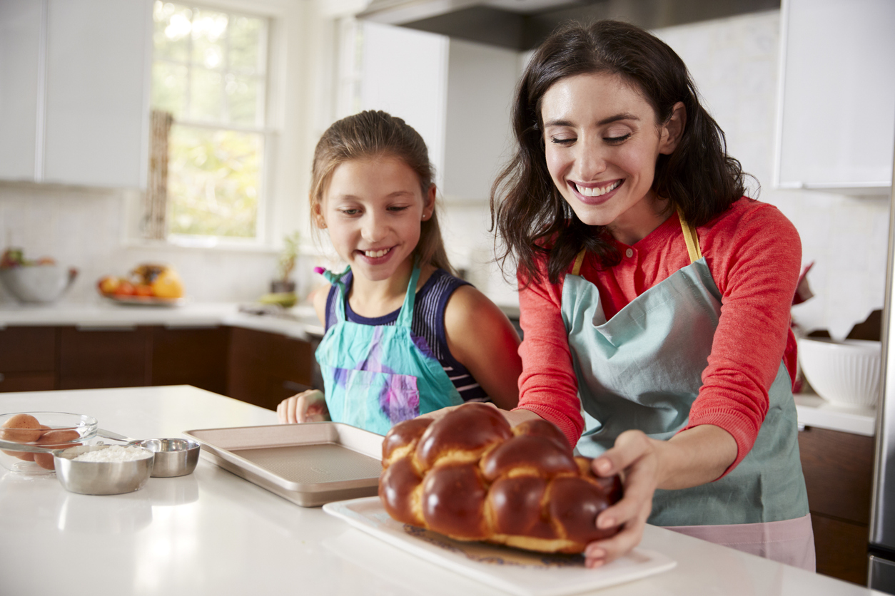 child and mom making challah together