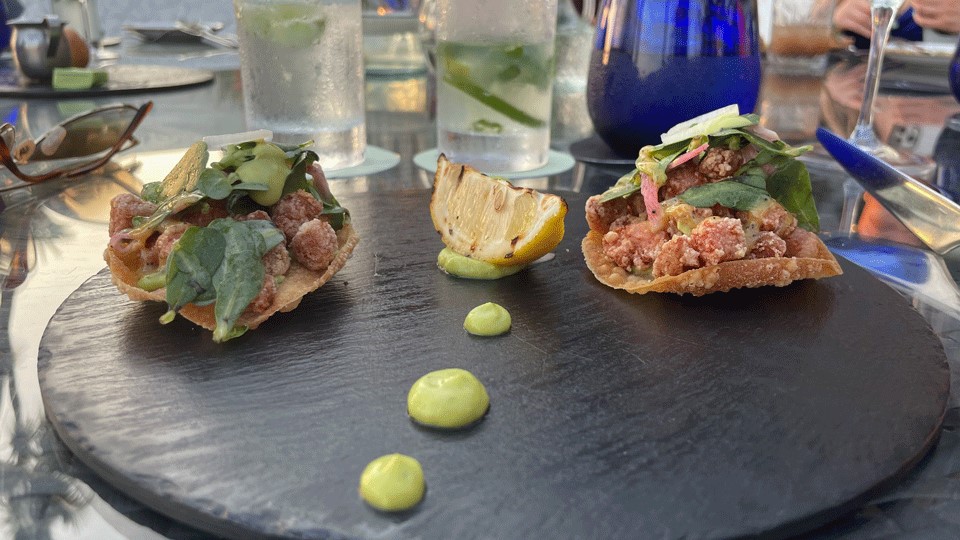 Arrefices Restaurant in Puerto Vallarta serves candied ahi tuna with green sauce dallops on a black plate