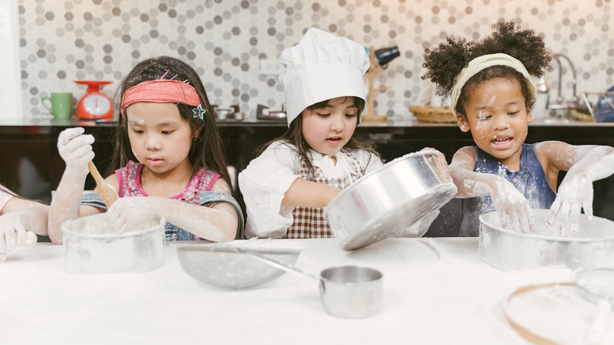 Three young girls baking in a family competition based off a tv show