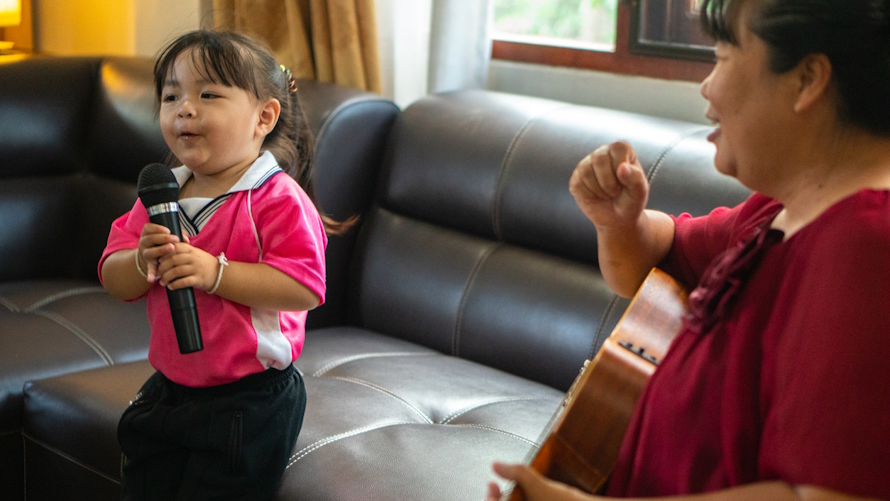 Little girl singing at home in a family competition based on a tv show