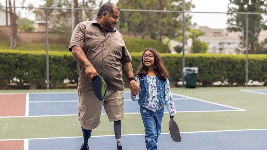 Father and daughter smiling on a pickleball court near Seattle after a fun game