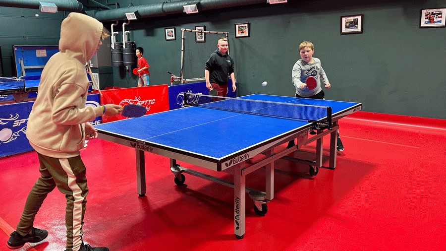 Young boys play table tennis (also known as ping-pong) at a local Seattle table tennis club