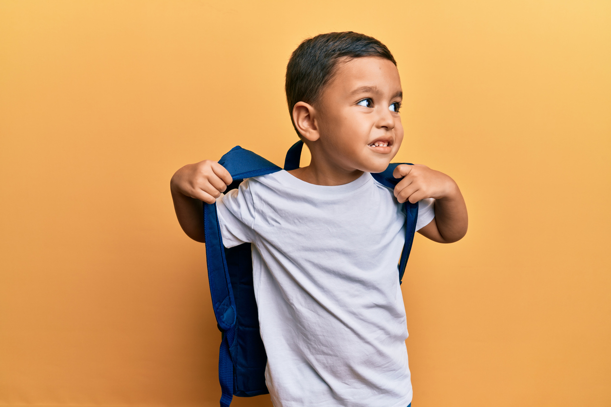 cute latino toddler wearing a backpack