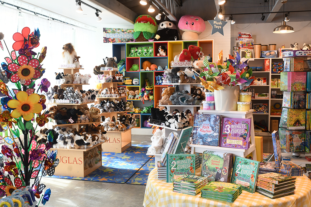 A family check out all the toys for sale at Calico Toy Shop in Winslow on a ferry day trip to bainbridge island near Seattle