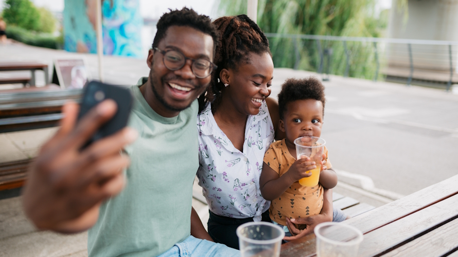 Young family taking a selfie while on vacation with a young child