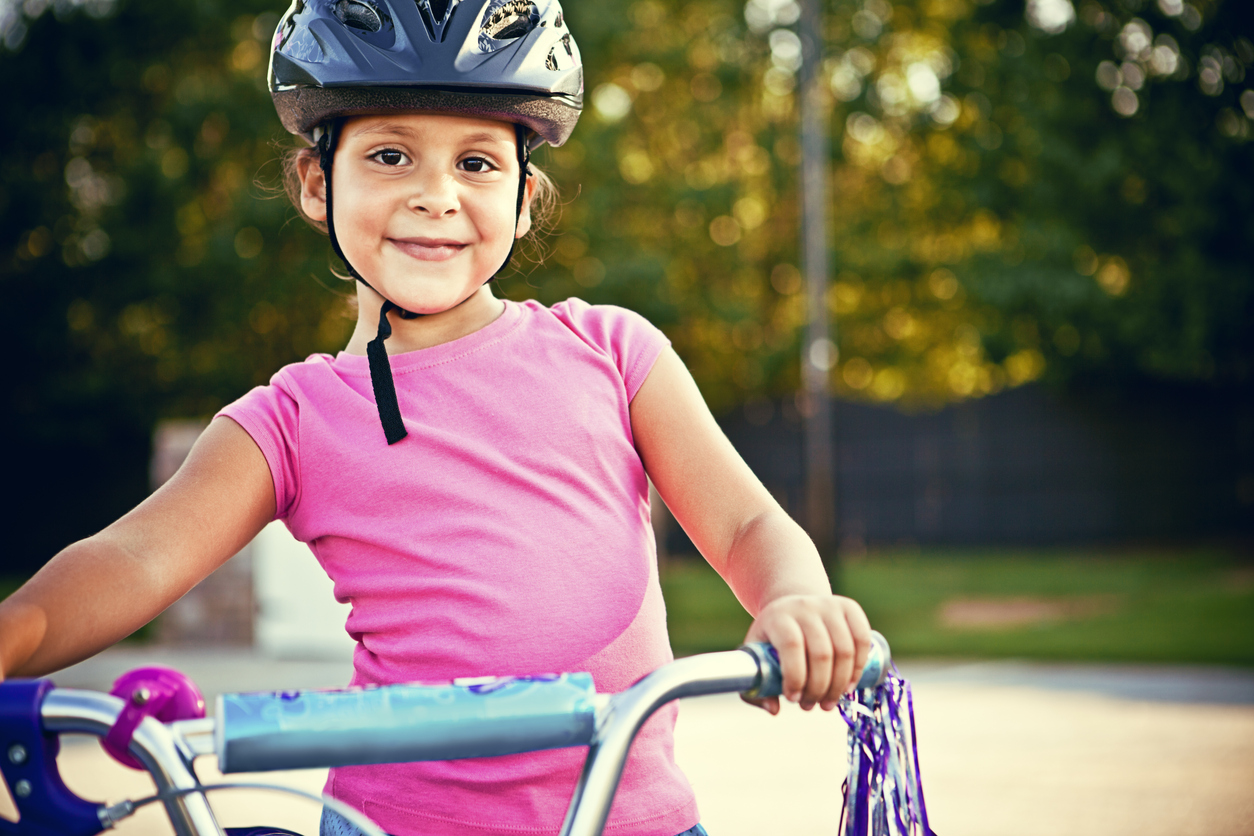 Girl wearing helmet holding bike handlebars bicycling families help cancel climate change