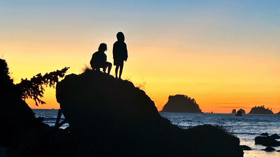 Kids on a rock at sunset after hiking Ozette Loop in Olympic National Park