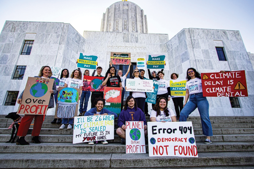 Group of teenagers outside a government building holding environmental protest signs