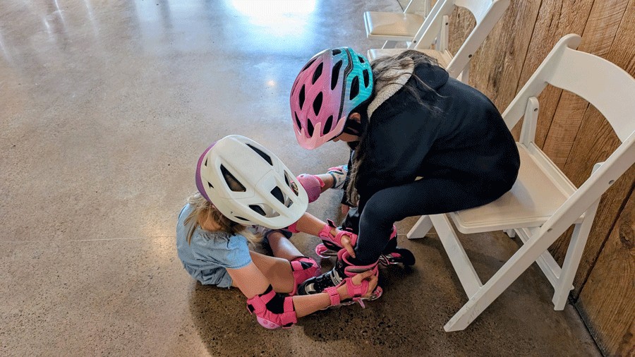 young girls helping each other with skates at Rock and Roll Rink in Issaquah