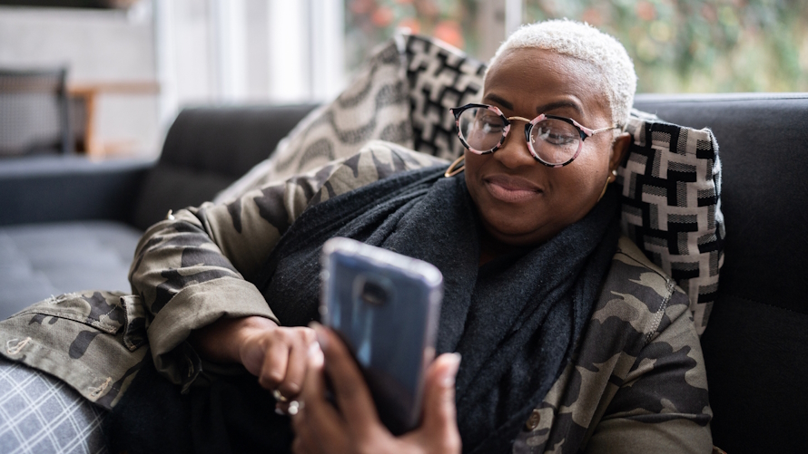 Woman watching a TikTok parenting tip video on the couch