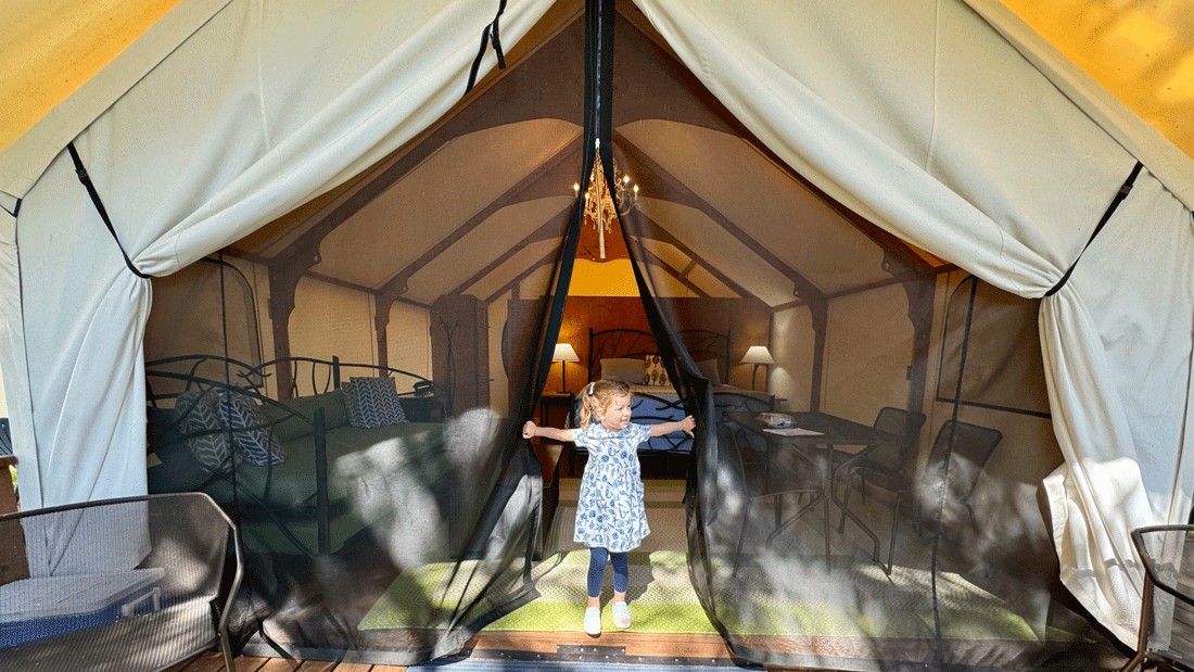 young girl opening entrance to family glamping tent at Lakedale, a summer destination for Seattle-area families