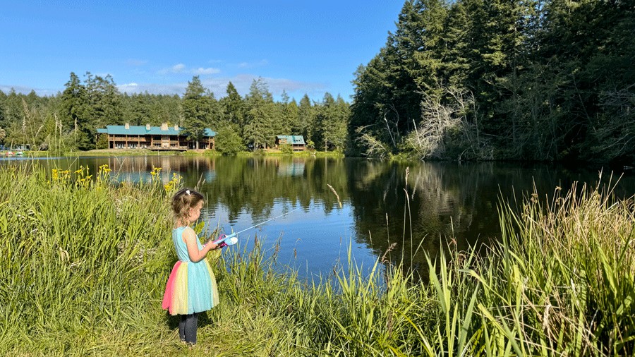 young girl fishing from the meadow at Lakedale during a family glamping trip