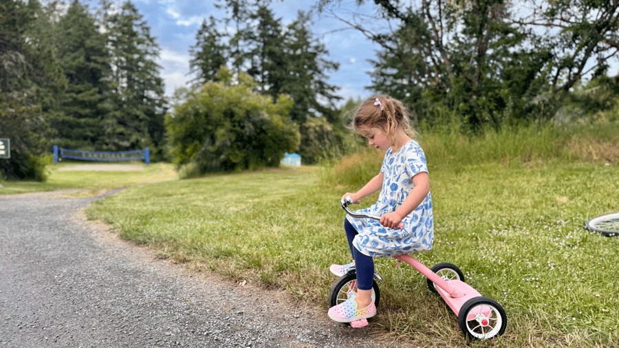 yougn girl riding bike at lakedale during a family glamping trip