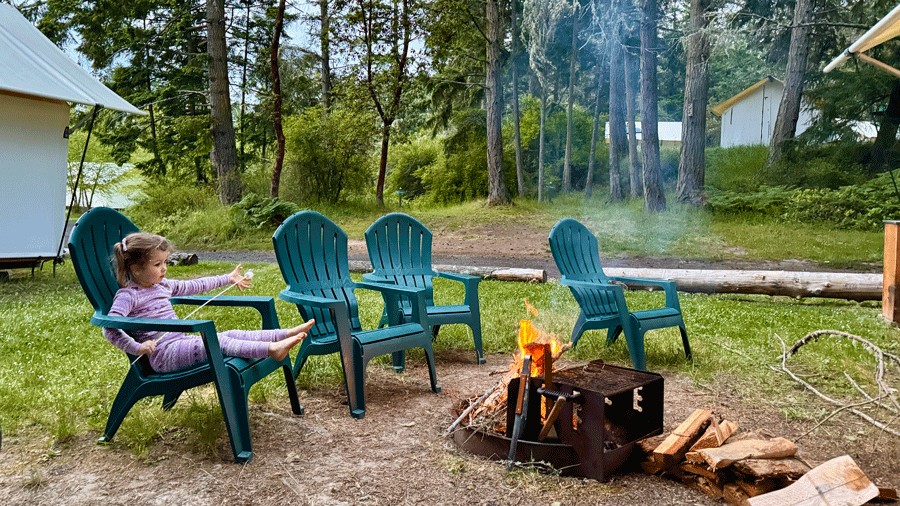 young kid roasting a marshmallow for s'mores during a family glamping trip near seattle