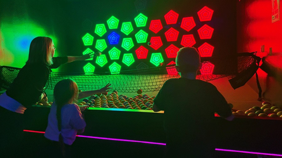 family throwing foam balls at arcade lights