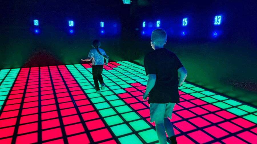 children hopping on colored tiles at C.H.E Arcade in Bellevue, an interactive family activity