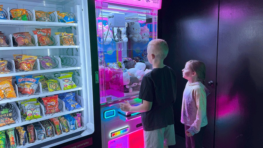 Kids playing an arcade game in the lobby of C.H.E Arcade
