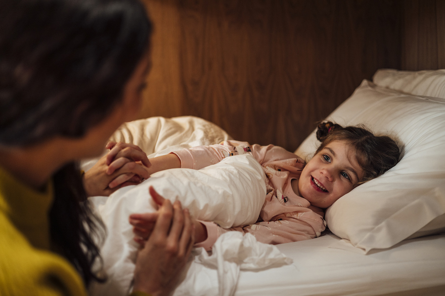 parent getting a child ready for sleep to prepare for back to school